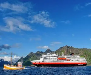Hurtigruten Cruises ship beside small boat in norway