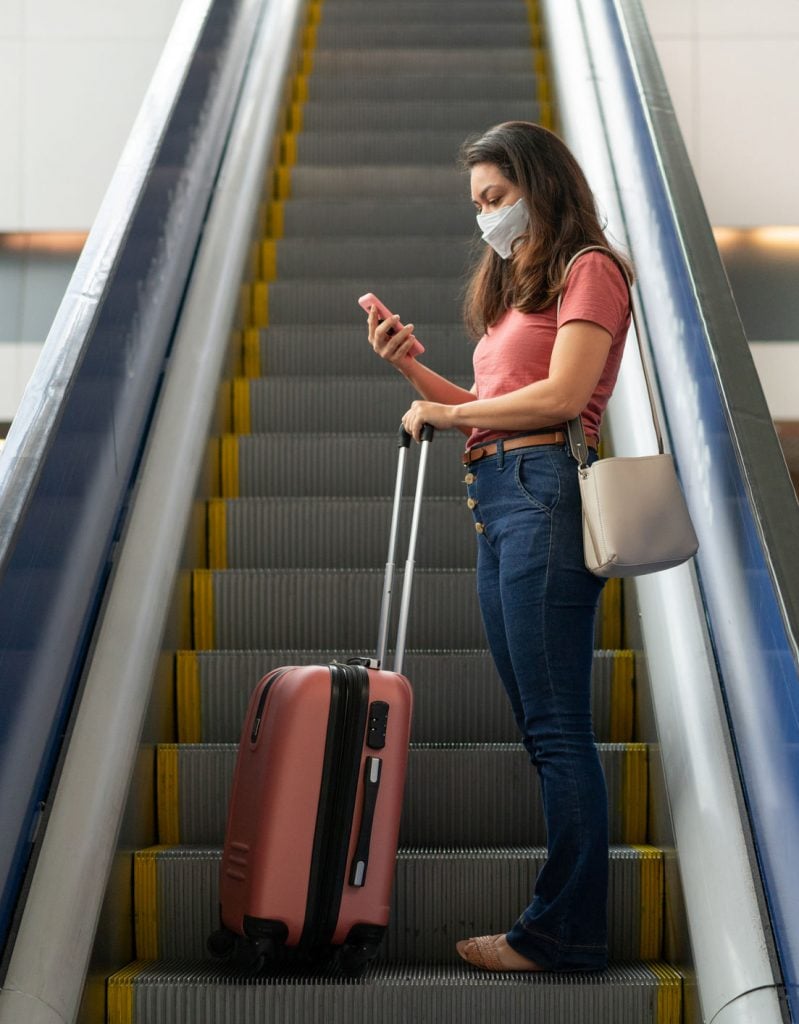 American tourist wearing a mask during covid19 on escalator