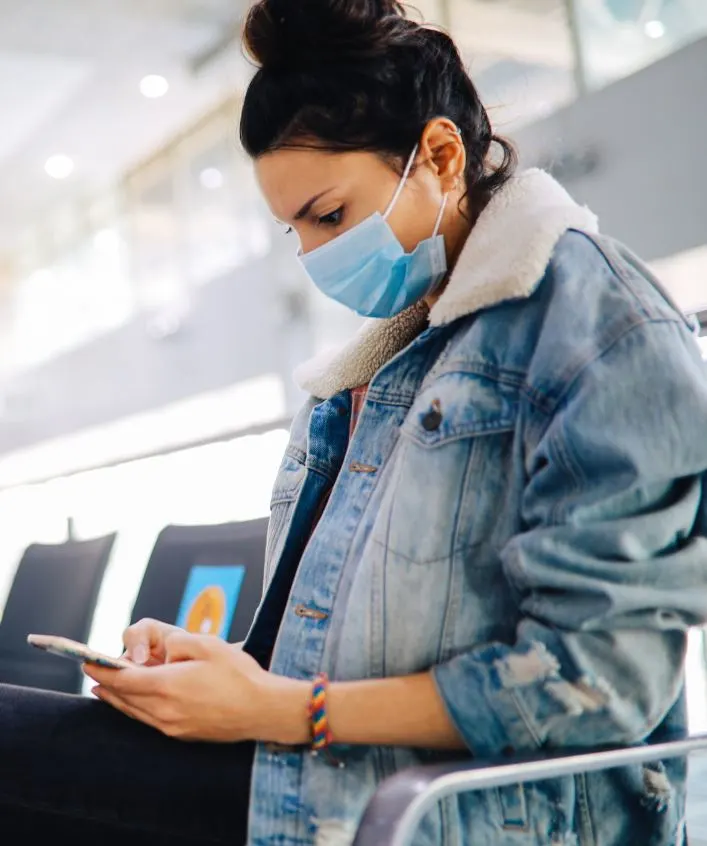 woman checking in for flight airport mask