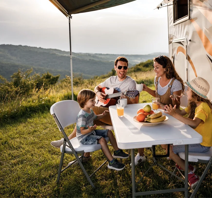 family eating smiling by camper van