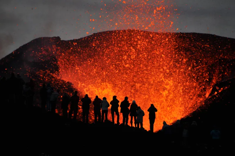  group of adventurers witnessing the eruption of volcano Eyjafjallaj&ouml;kull 