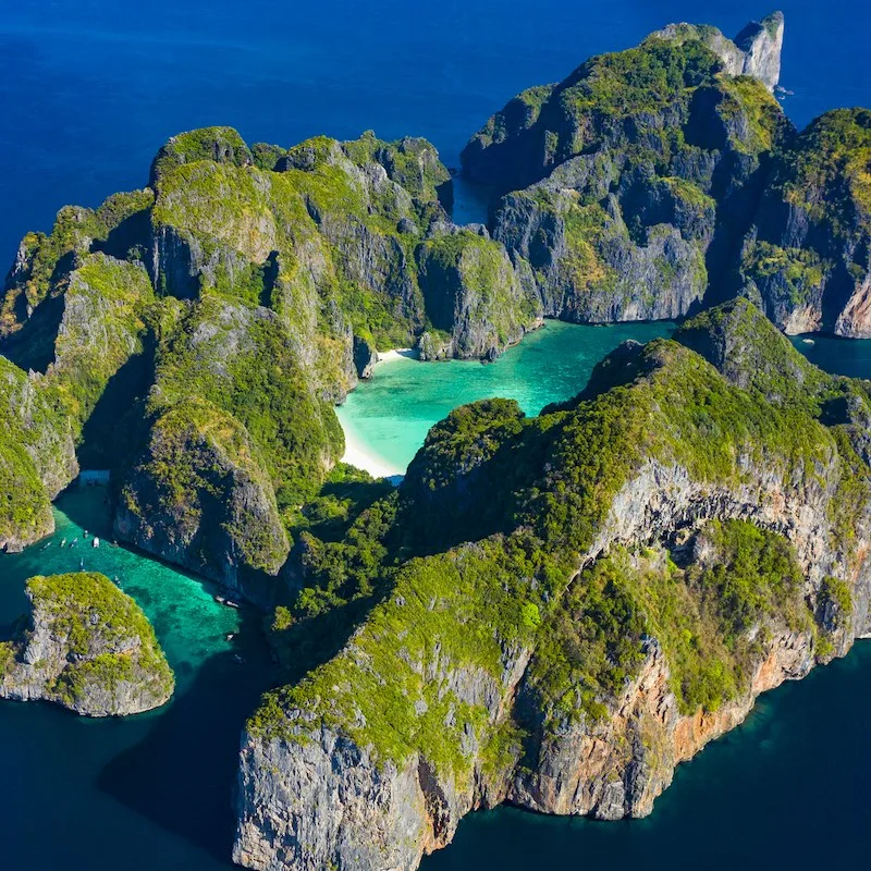 View from above, stunning aerial view of Koh Phi Phi Leh (Phi Phi Islands) with the beautiful Maya Bay. A turquoise and clear water bathes a white beach surrounded by limestone mountain
