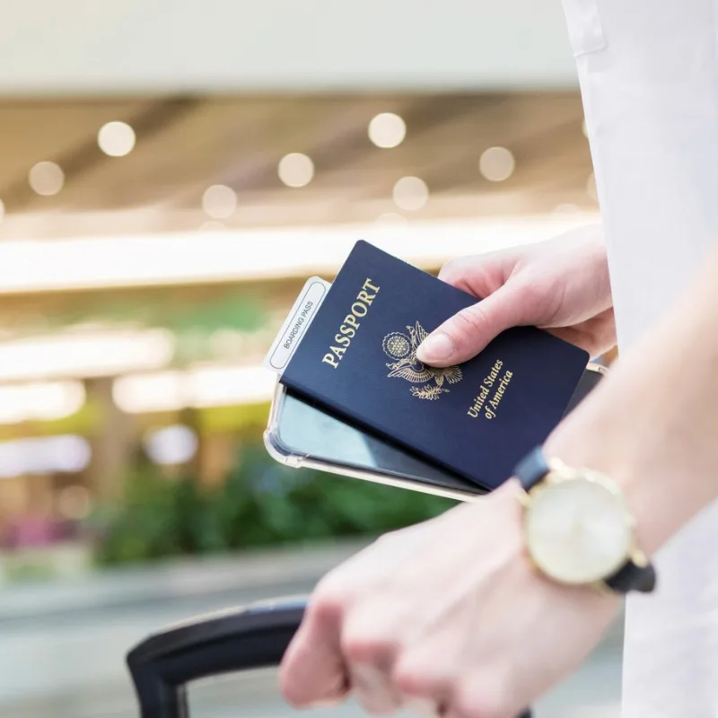 Woman Prepares For International Travel Holding US Passport And Luggage