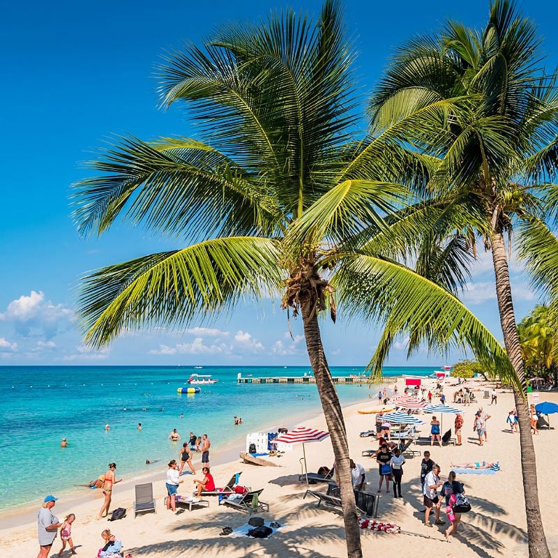 People enjoy Doctor's Cave Beach in Montego Bay, Jamaica on a sunny day.