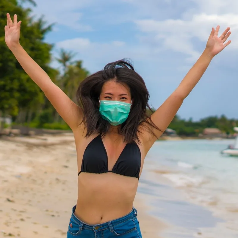 Young Thai Woman Wearing A Face Mask At The Beach In Thailand, South East Asia