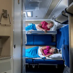 Happy Couple Chatting From Their Berth As They Enjoy Their Stay At Amtrak's Sleeper Train, Train Travel Concept