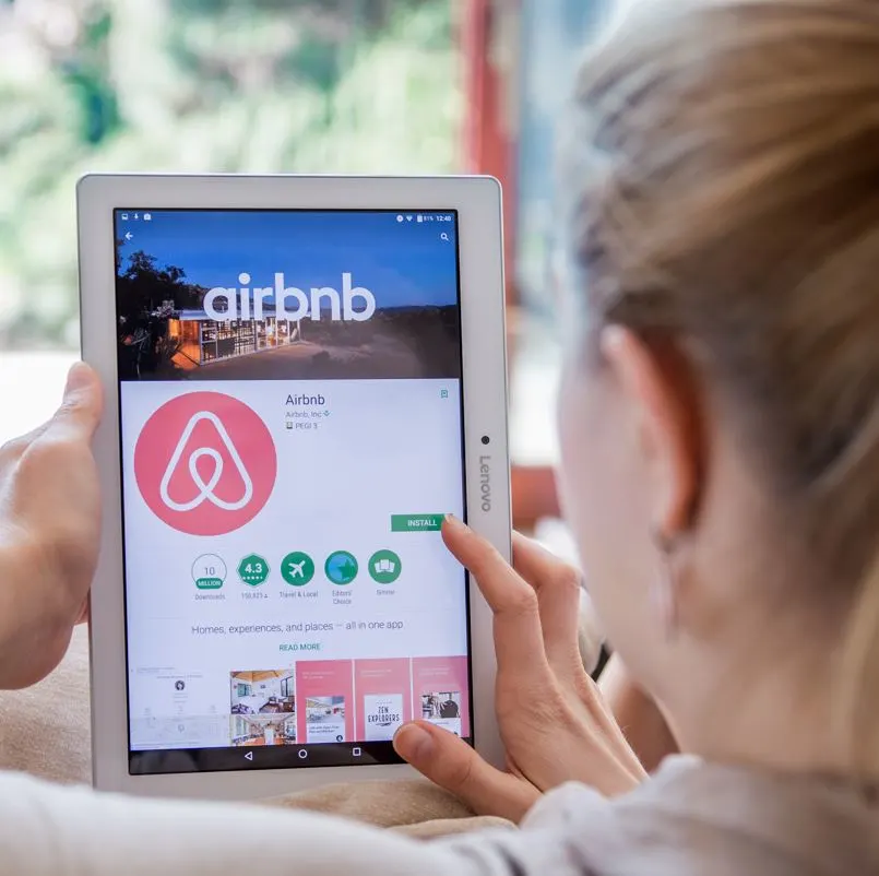 Woman Installing airbnb on tablet