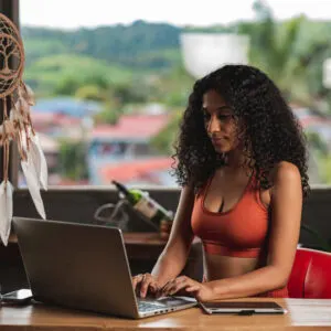 Young Female Remote Worker Working From Her Laptop In A Relaxing Setting In Costa Rica, Central America