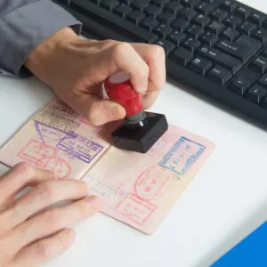 Immigration Officer Stamping A Passport At Border Control