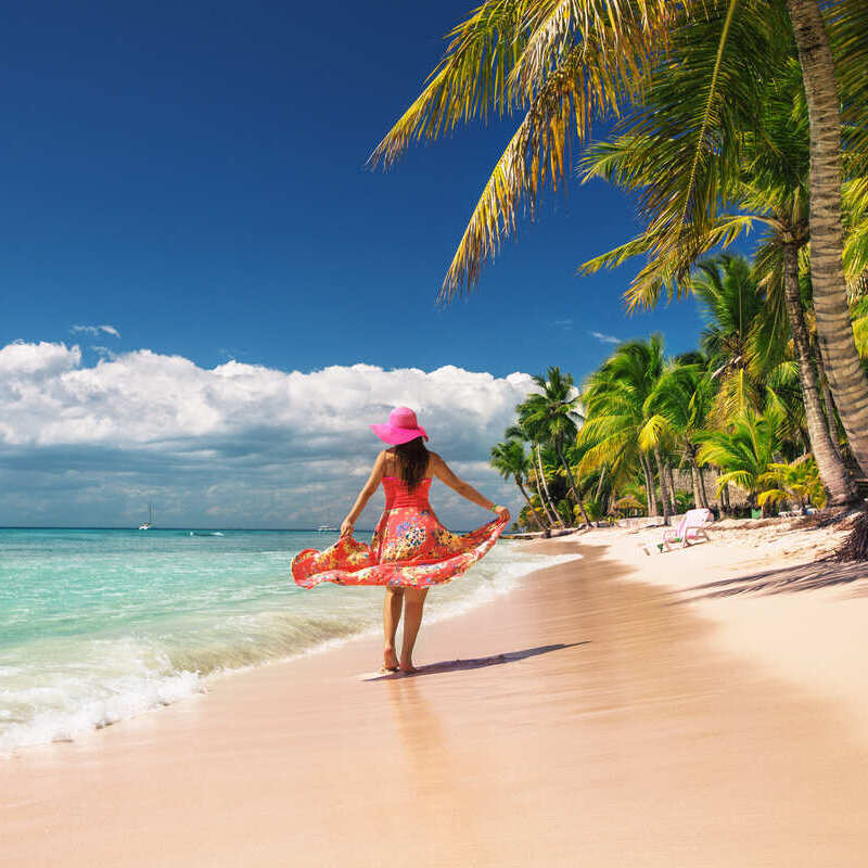 Young Female Tourist Walking On The Beach In The Dominican Republic, Caribbean Sea