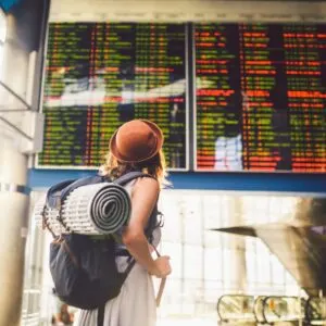 Backpacker Observing Flight Schedules At The Airport