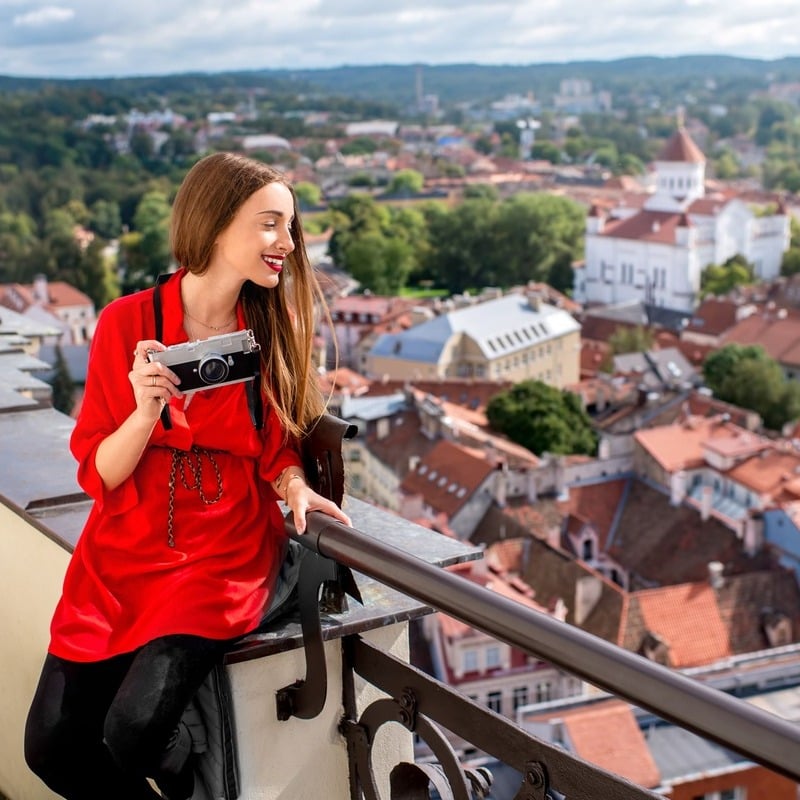 Ung kvinnlig fotograf poserar för en bild vid en utsiktspunkt med utsikt över Vilnius, Litauen, Östeuropa, Europeiska