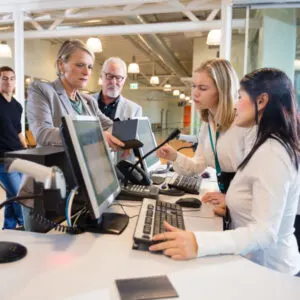 Businesswoman Looking At Staff Working At Airport Check-in