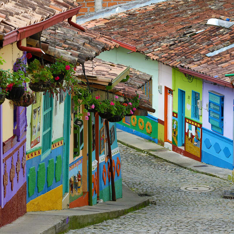 Colorful Houses Lining A Historical Cobblestone Paved Street In Guatape 