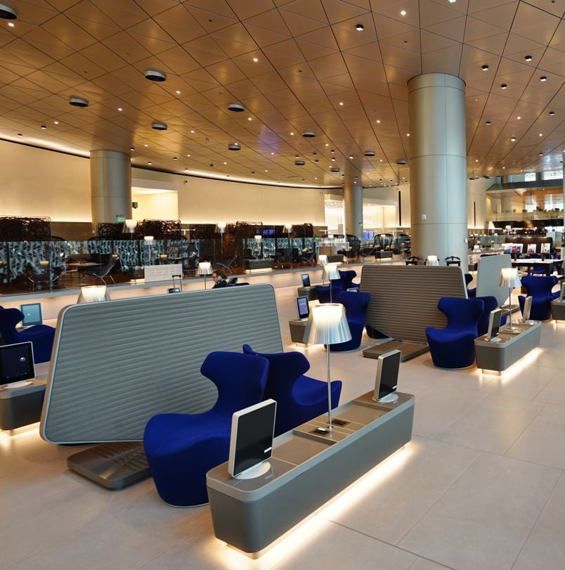 Doha Qatar Business Class airport lounge with luxury blue lounge chairs and LED lighting