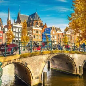Image of a bridge over a canal in amsterdam with bikes locked up along the guard rails