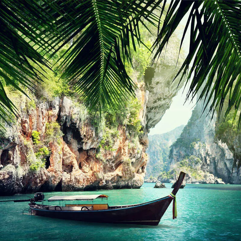 Long Tail Boat Docked In A Bay Surrounded By Nature And Geological Formations In Thailand, Southeast Asia