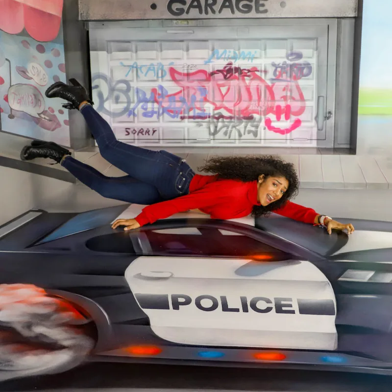 Museum of Illusions Miami containing woman flying over police ca