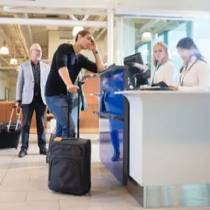 Staff Checking Passport Of Male Passenger At Counter In Airport 800