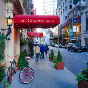 an exterior view of the Chatwal hotel with a red awning and matching bicycles