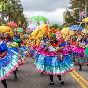 people in the Dominican Republic are dressed in colorful costumes as they walk down the street during a Carnival parade