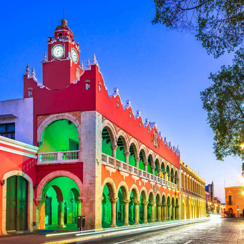 Röd kolonialbyggnad upplyst av grönt ljus i Gamla stan Merida, Yucatanhalvön, Mexiko