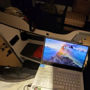 traveler working on a laptop in a sleeper train cabin