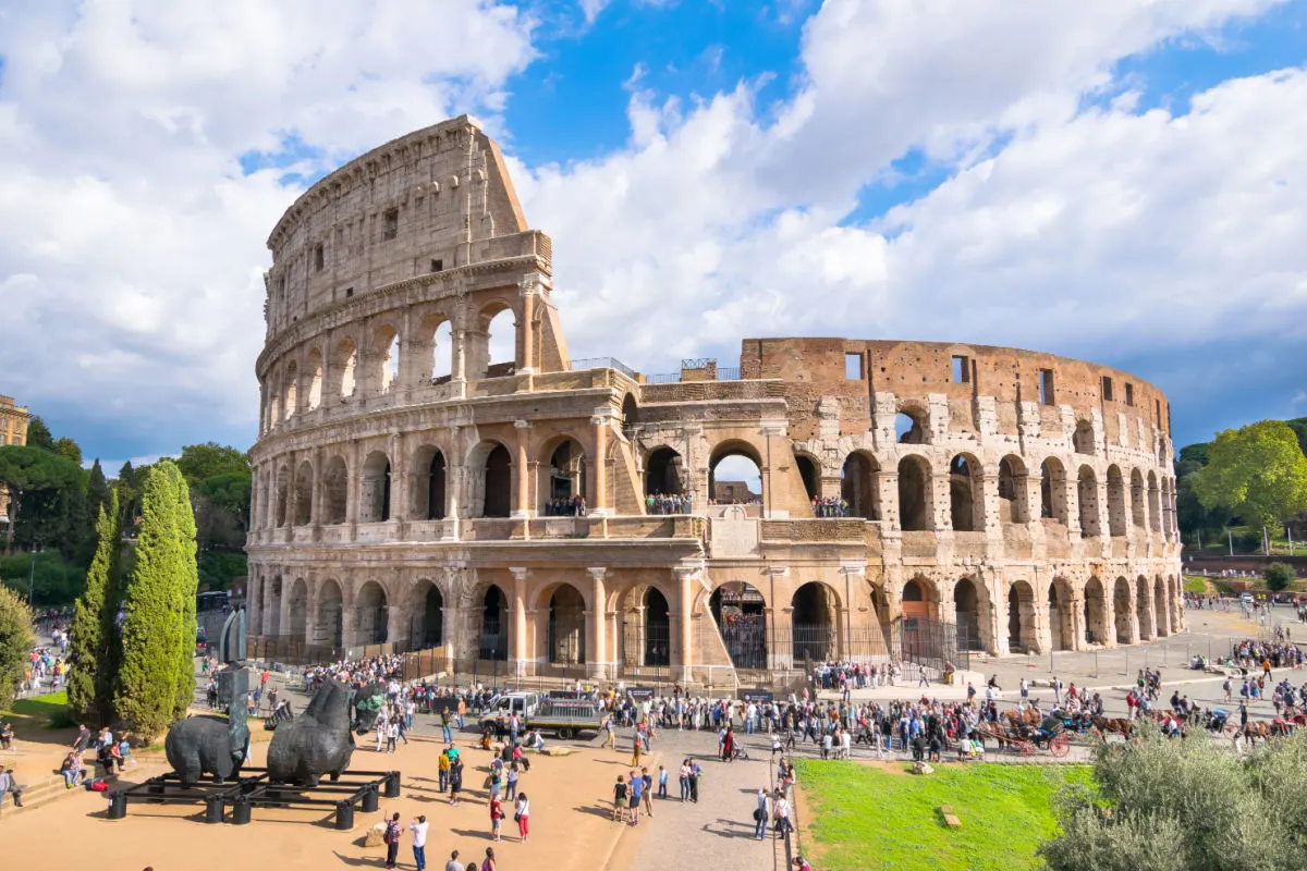 Crowds of tourists standing around the Colosseum in Rome Italy