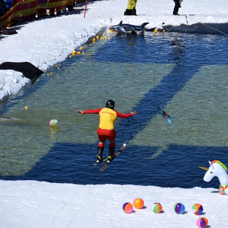A spring skier participates in a pond-skim competition