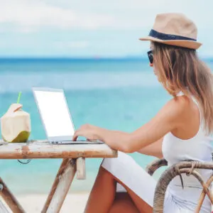 woman on beach with laptop