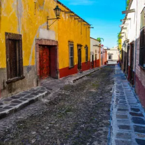 A Charming Cobblestone Street Lined With Colorful Buildings In San Miguel de Allende, A Colonial Era City In Mexico, Latin America