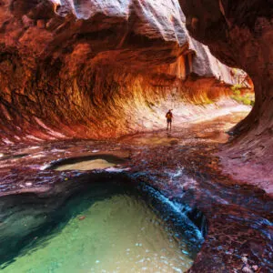 A clear pond inside a red rock formation at Zion National Park