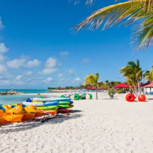 colorful paddleboats and kayaks wait for beachgoers to use them on a beach in the Bahamas