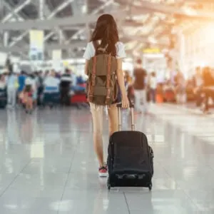 A young girl with luggage in an airport