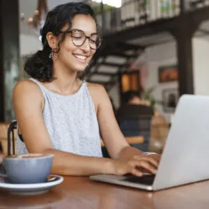 Woman On Computer Working From A Cafe, Unspecified Location