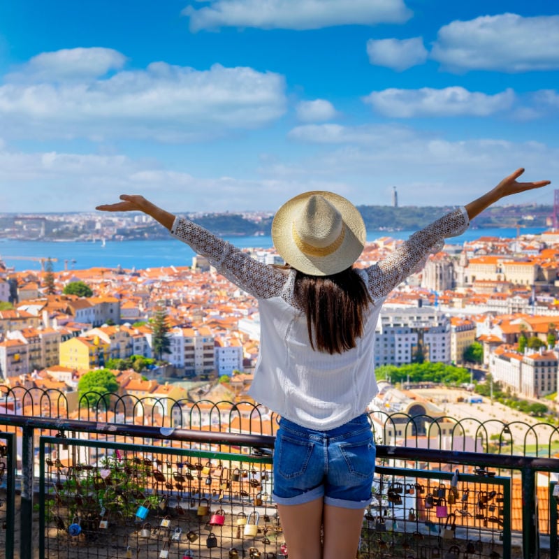 Woman standing at scenic overlook in Portugal