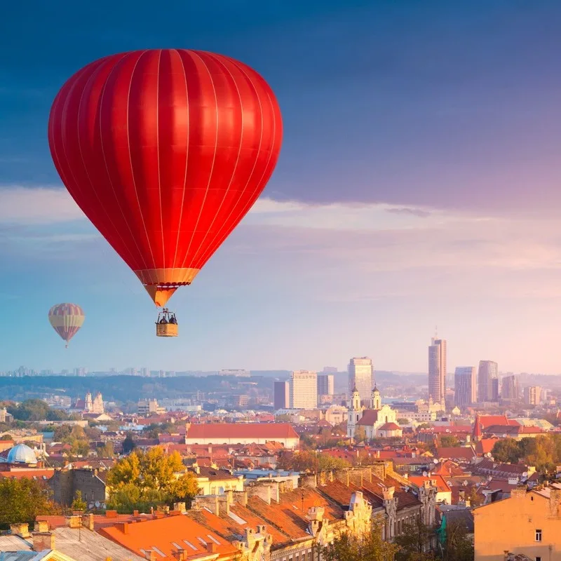 A Red Hot Air Balloon Hovering Above Vilnius Old Town, The Capital Of Lithuania, North Eastern Europe
