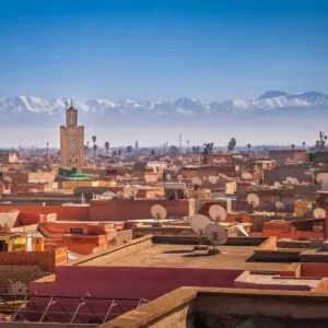 Panoramic View Of The Marrakech Skyline With The Roofs Of The Red-Colored Medina And Koutoubia Mosque Standing Out, Atlas Mountains In The Background, Morocco, North Africa