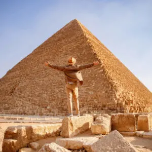 Travel man in hat stand background Egyptian pyramid sunset Giza Cairo, Egypt.