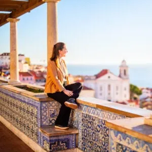 A Young Woman Sitting On A Miradouro In Lisbon, Portugal, Western Europe