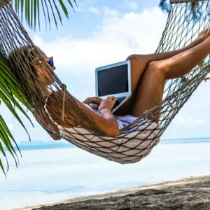 Woman on laptop in a hammock