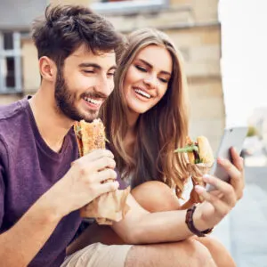 young couple eating sandwiches
