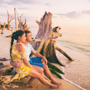 young couple relax on florida beach at sunset