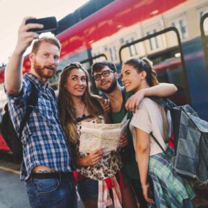 A Group Of Friends Taking A Selfie In Front Of A Red Train, Unspecified Location