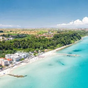 Aerial View Of The Lively Kallithea Resort Town In Halkidiki Peninsula, Northern Greece, Lapped By The Teal-Colored Mediterranean Sea, South Eastern Europe
