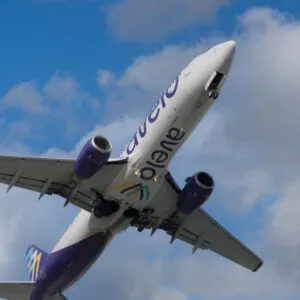 An Avelo plane against a blue sky