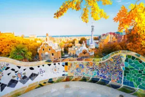 Gaudi mosaic bench detail and skyline of Barcelona from park Guell at sunset, Catalonia Spain at fall