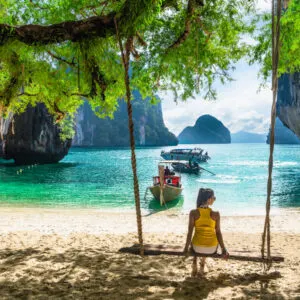 Woman on a swing at a beach in Thailand