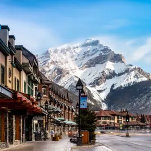 empty street with snow covered mountains in the baclground
