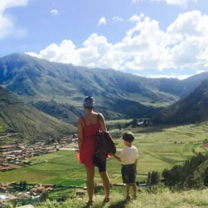 mother and son holding hands together and facing mountains